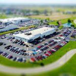Aerial view of a car dealership lot with rows of new vehicles