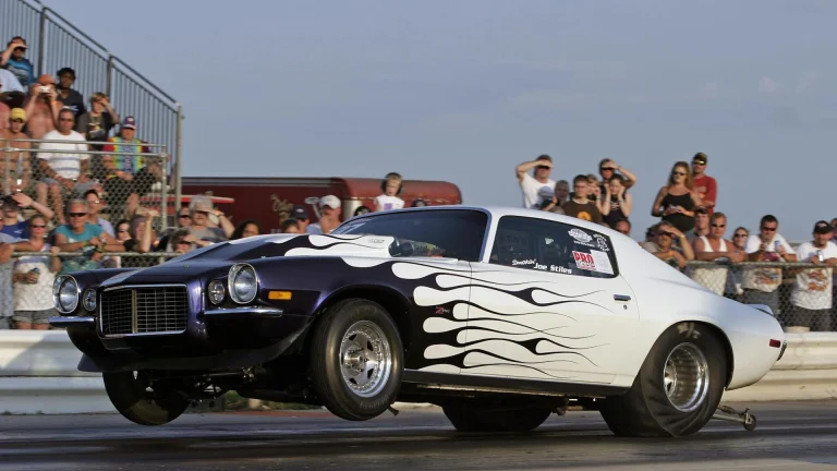 dramatic drag race car launch with spectators