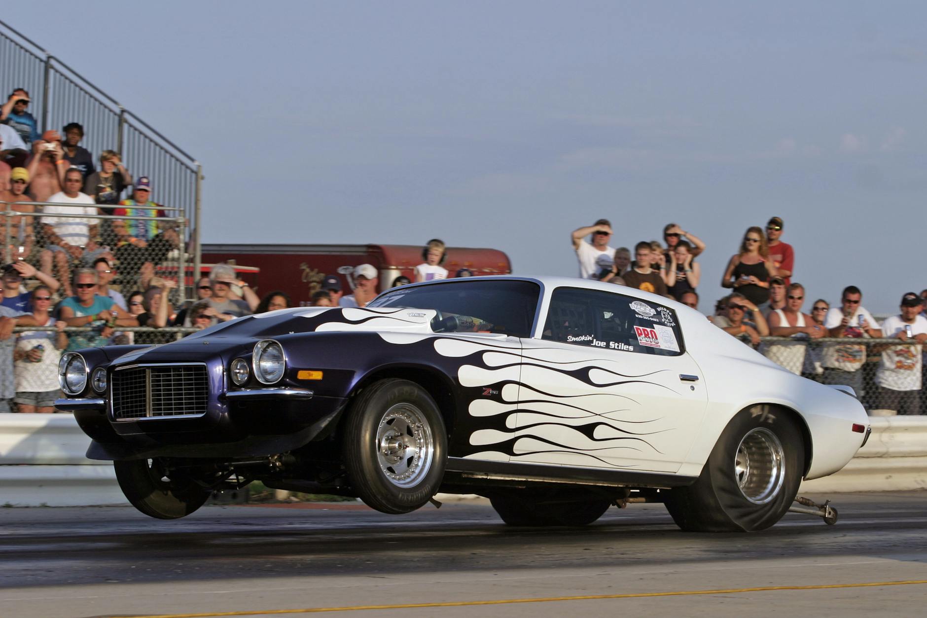 dramatic drag race car launch with spectators