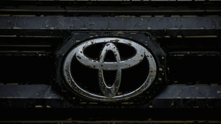 Close up of a dirty toyota car emblem on grille.