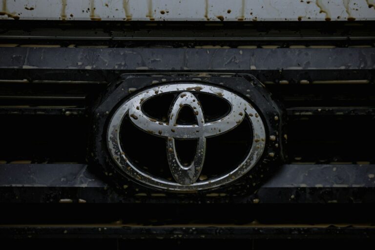 Close up of a dirty toyota car emblem on grille.