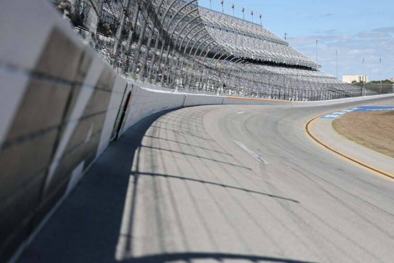 A racetrack curve and grandstands are shown.