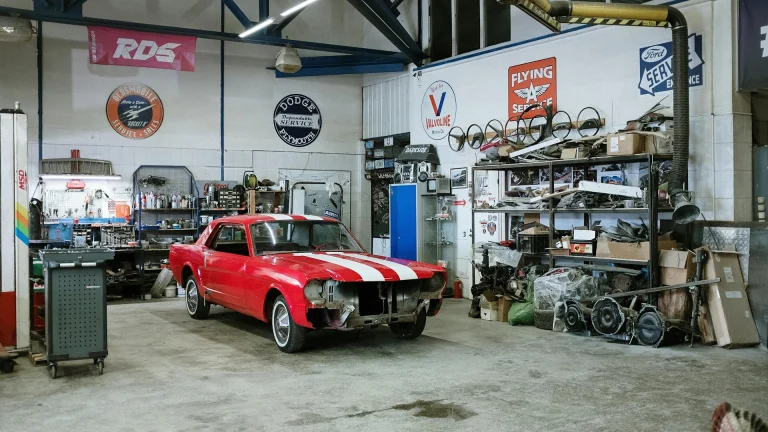 red and white vintage car parked in front of blue and white food stall