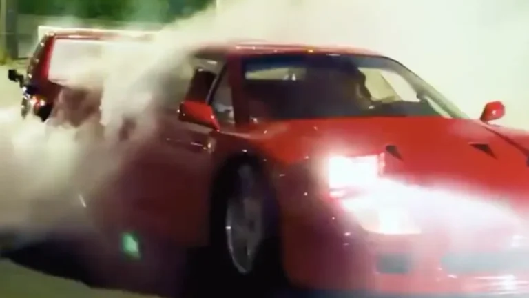 Lewis Hamilton's red Ferrari F40 with smoke around its rear tires
