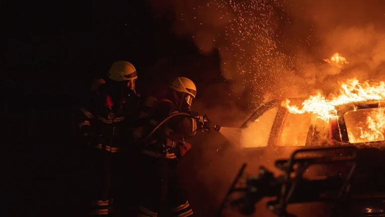 2 men in black helmet standing near fire