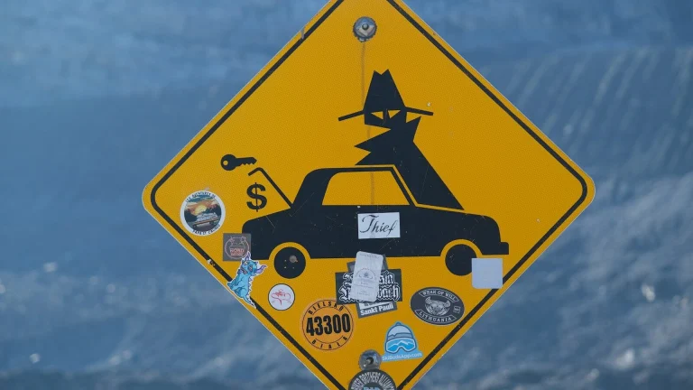Yellow diamond sign with silhouette of car and spy.