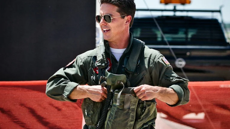A smiling pilot puts on his flight gear.