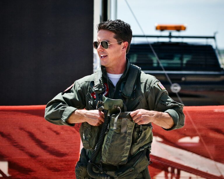 A smiling pilot puts on his flight gear.