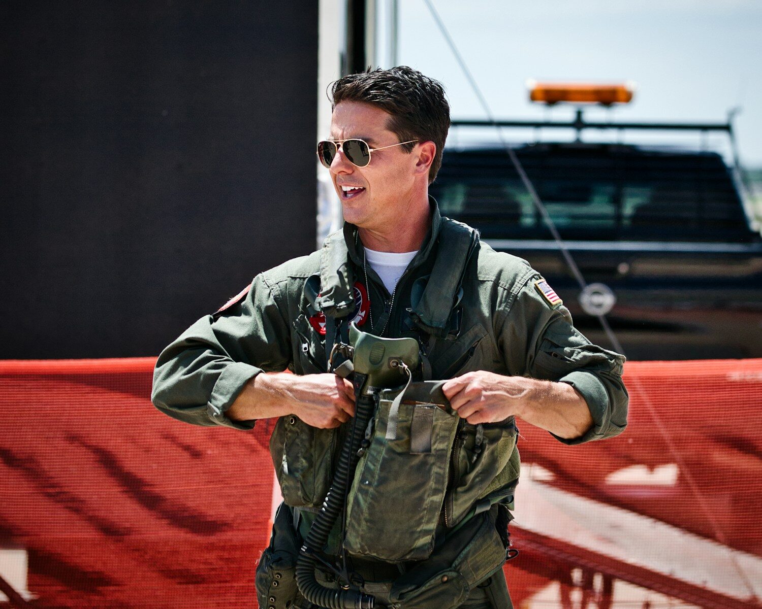 A smiling pilot puts on his flight gear.