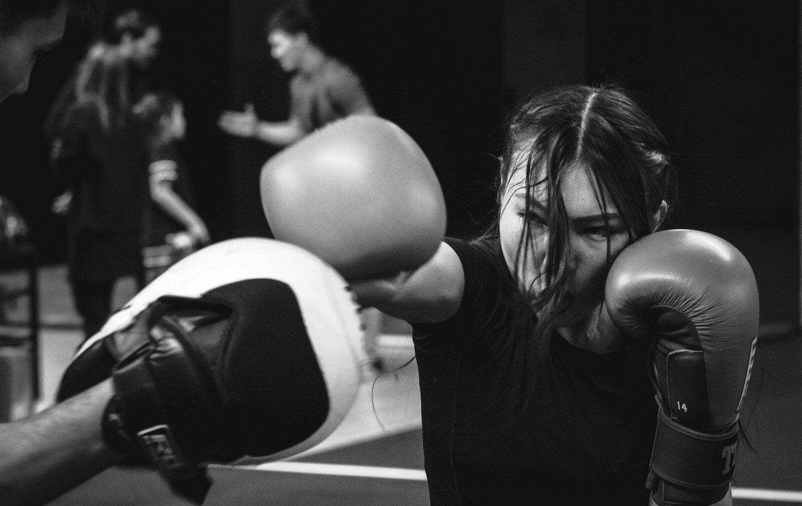 A man with long hair wearing boxing gloves