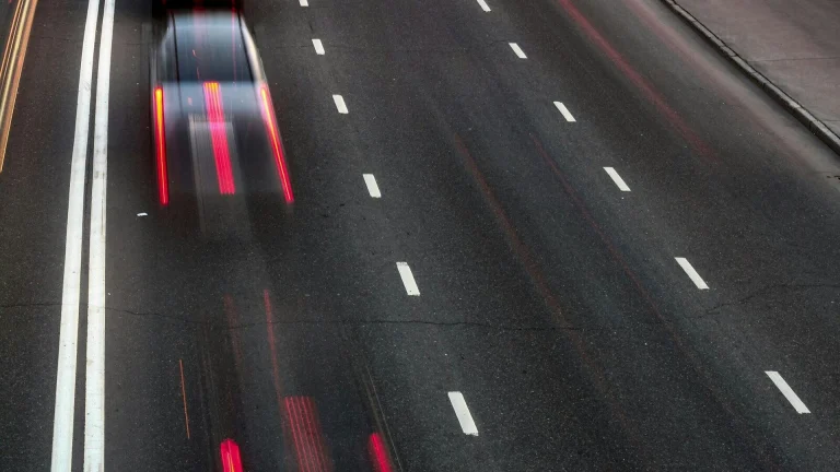 a car driving down a highway at night