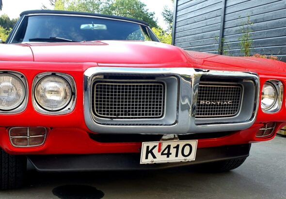 a red car parked in a driveway next to a building