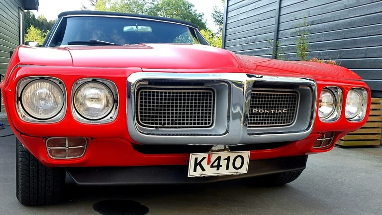 a red car parked in a driveway next to a building