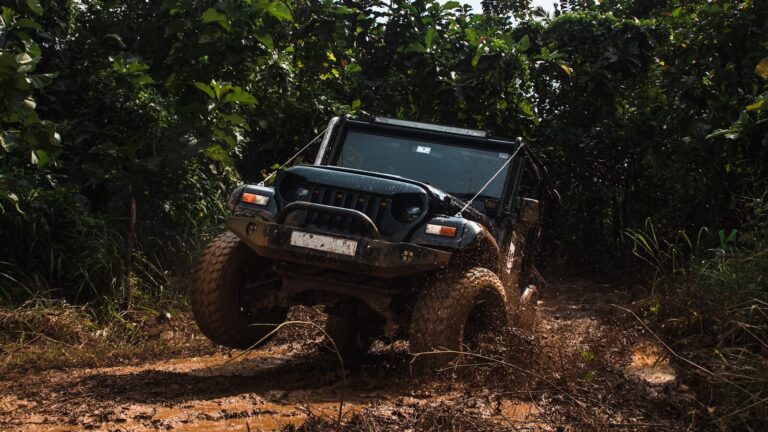 A black jeep driving through muddy terrain