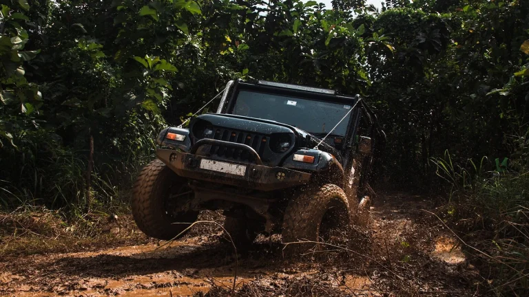 A black jeep driving through muddy terrain