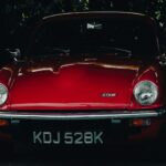 Red Aston Martin GT6 classic British sports car parked outdoors