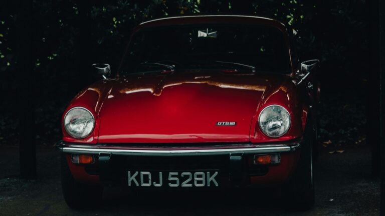 Red Aston Martin GT6 classic British sports car parked outdoors