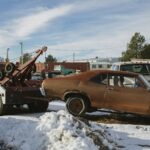 brown and white vintage car on snow covered ground during daytime