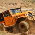 orange suv on brown sand during daytime
