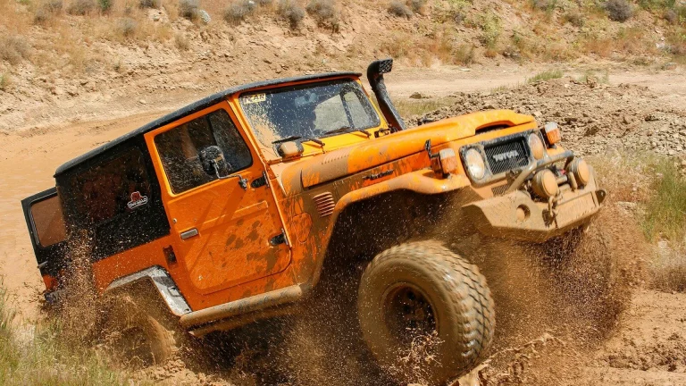 orange suv on brown sand during daytime