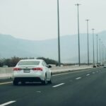 a white car driving on a road