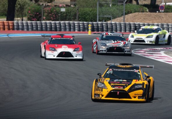 a group of cars driving down a race track
