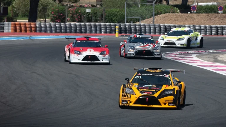 a group of cars driving down a race track
