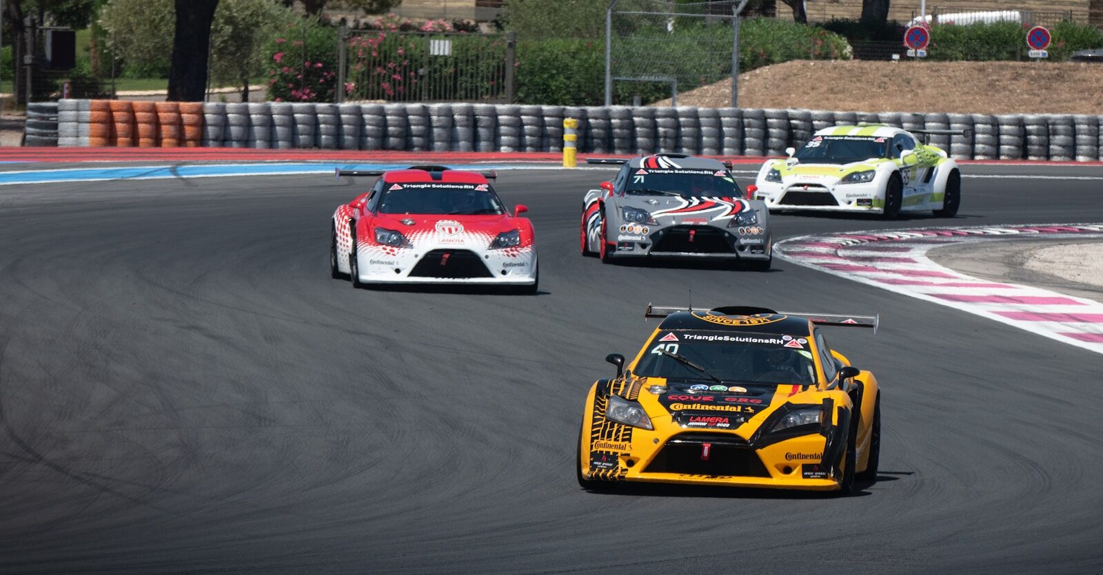 a group of cars driving down a race track
