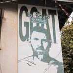 Mural of a soccer player with the word goat.