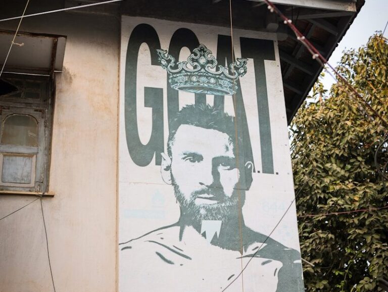 Mural of a soccer player with the word goat.