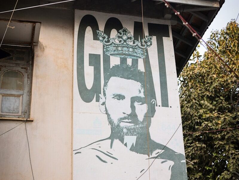 Mural of a soccer player with the word goat.