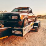 a truck is being towed on a flatbed trailer