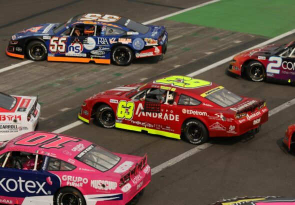 Stock cars racing side by side on a NASCAR short track