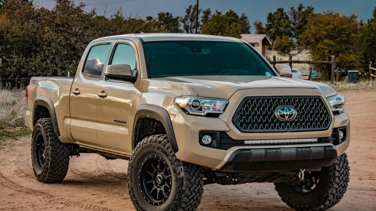 white Toyota crew cab pickup truck on ground