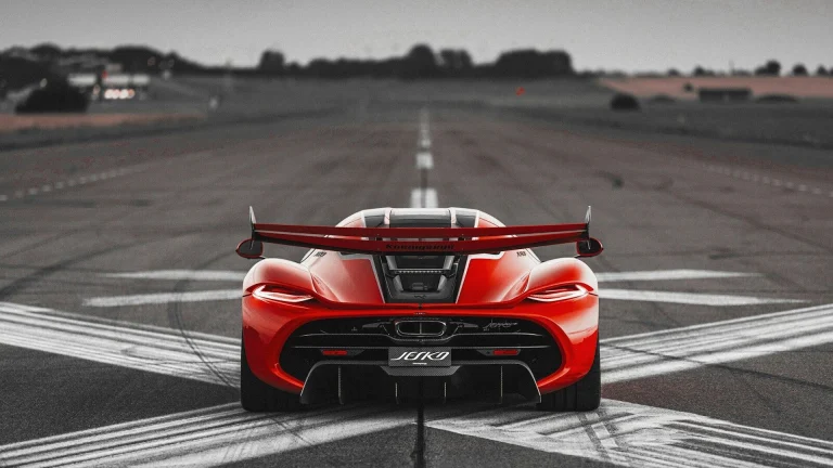 a red sports car driving down a runway