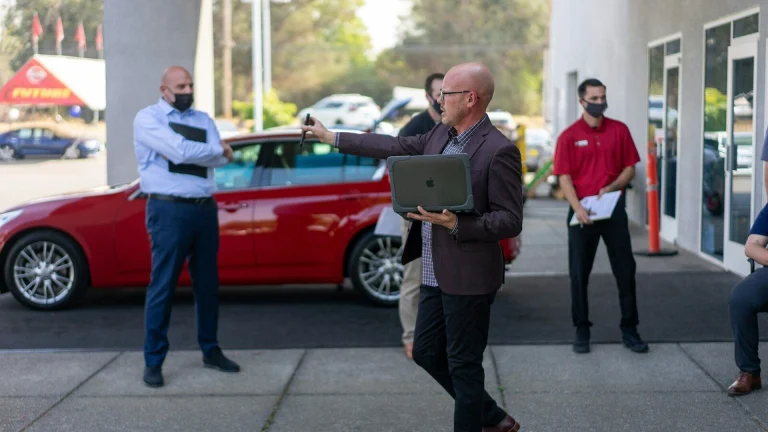 man in white dress shirt and black pants holding ipad