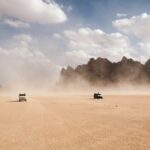 2 cars racing on dusty desert