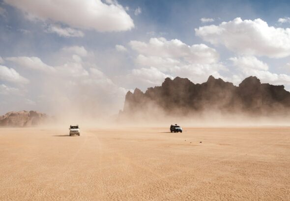 2 cars racing on dusty desert