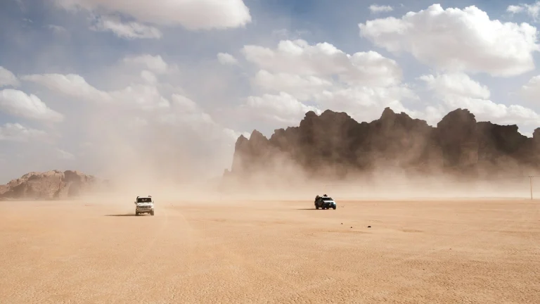 2 cars racing on dusty desert