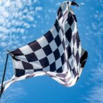 a black and white checkered flag flying in the sky