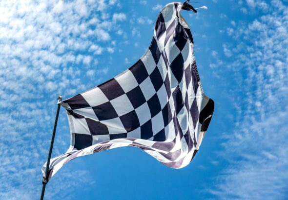 a black and white checkered flag flying in the sky