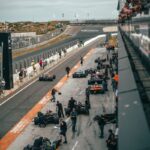 a group of people around a race car on a track