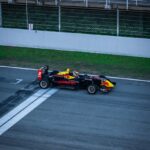 a red and yellow race car driving down a race track