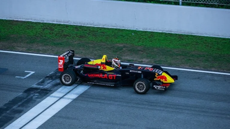 a red and yellow race car driving down a race track