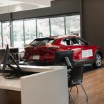 a red car is parked in a showroom