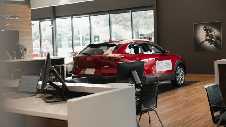 a red car is parked in a showroom