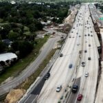 an aerial view of a highway with a train on it
