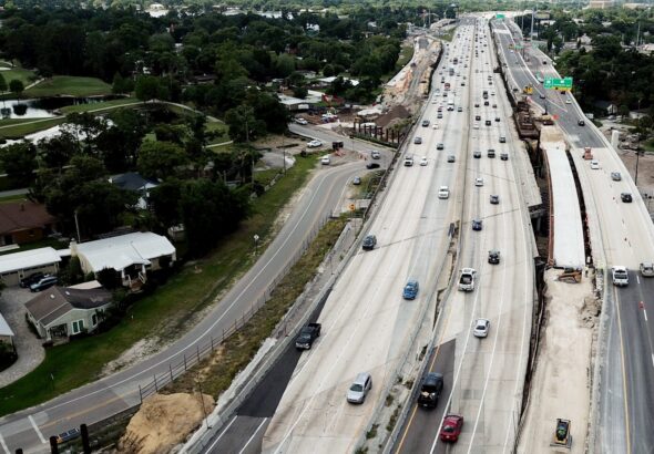 an aerial view of a highway with a train on it