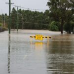 a flooded street with a yellow sign