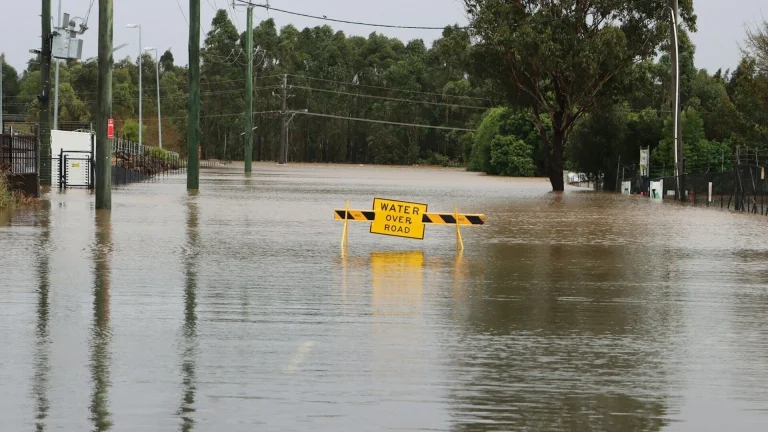 a flooded street with a yellow sign
